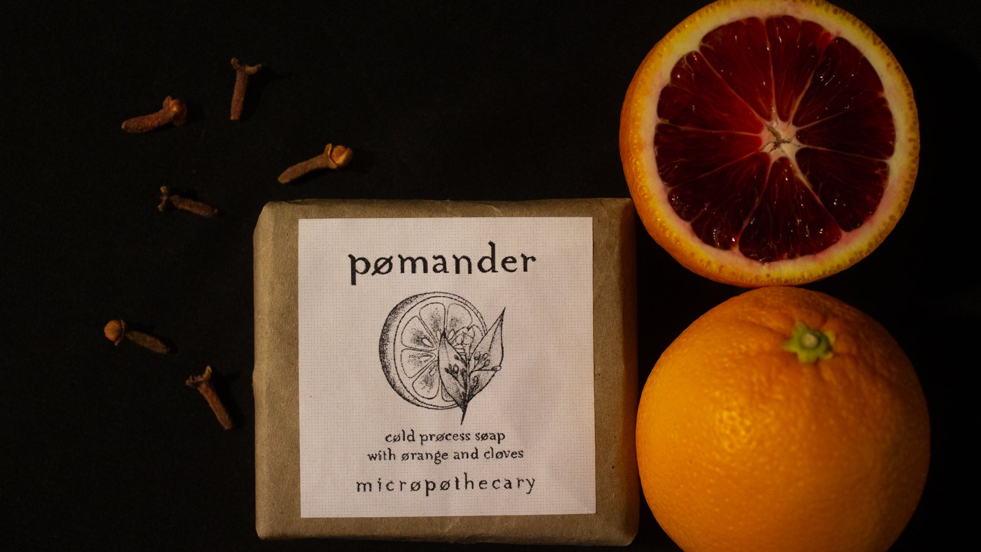 Pomander soap bar with oranges and cloves on a dark background
